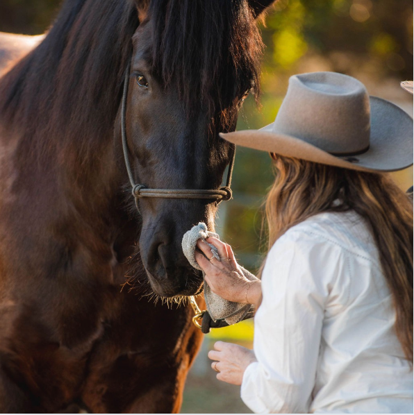 jen in hat using the reusable bamboo wiping cloth with black horse